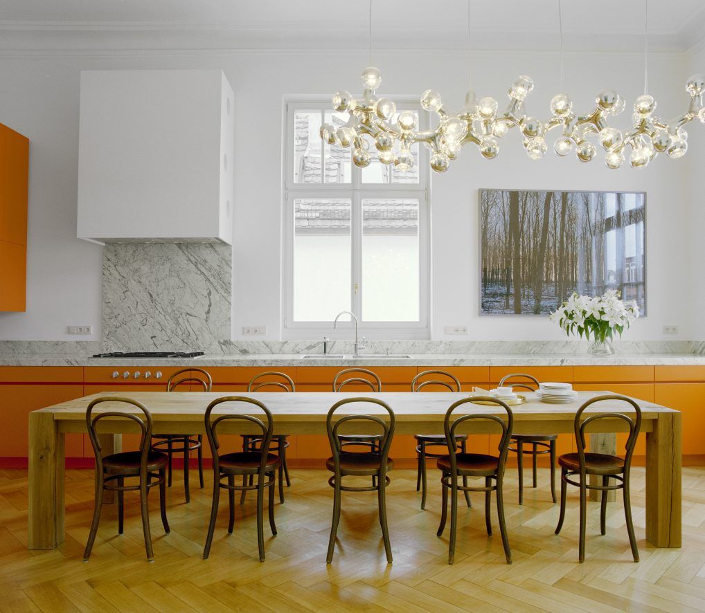 E15 Bigfoot Tisch: Massiver Holztisch im Esszimmer mit Stühlen und moderner Beleuchtung.