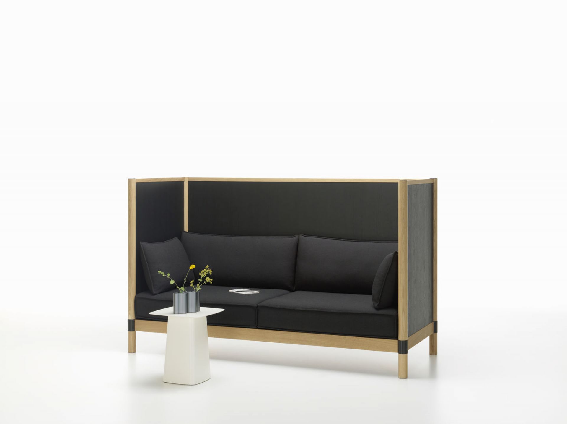 Weißer Metal Side Table Beistelltisch Medium von Vitra neben schwarzem Sofa mit Holzrahmen.